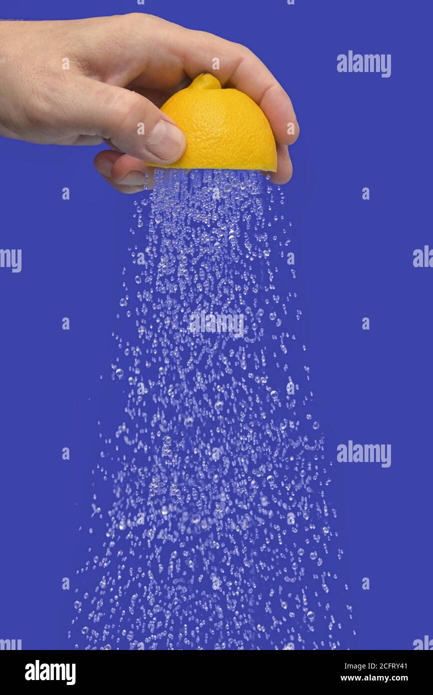 Concettuale acqua che scorre doccia da Squeeze metà di UN limone Foto Stock