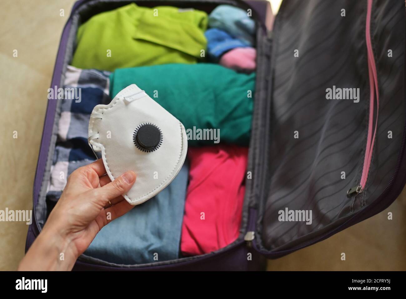 Borsa da viaggio sicura con abiti e maschere mediche Foto Stock