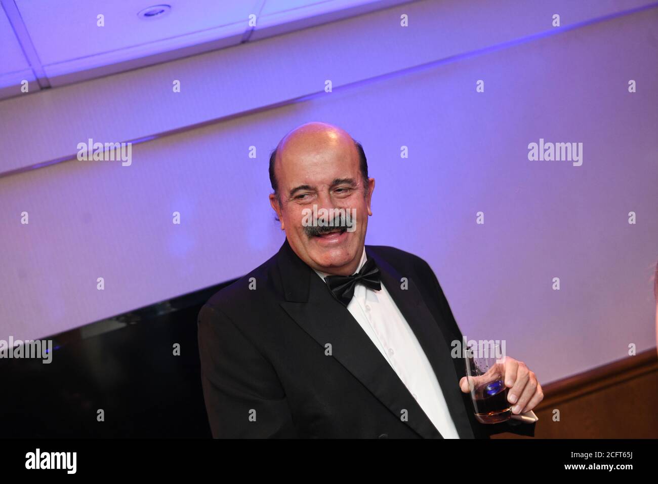 Nella foto è l'ex giocatore di snooker Wille Thorn in una giacca da cena e un bicchiere contenente una bevanda in mano mentre sorride. Foto Stock