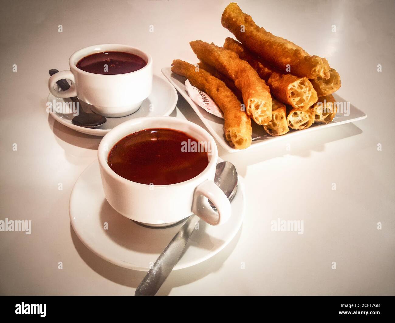 Tazze di cioccolata calda e churros: Colazione spagnola con un amico Foto Stock