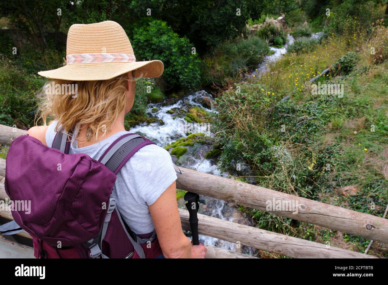 Donna con un cappello in un ponte e fiume. Foto Stock
