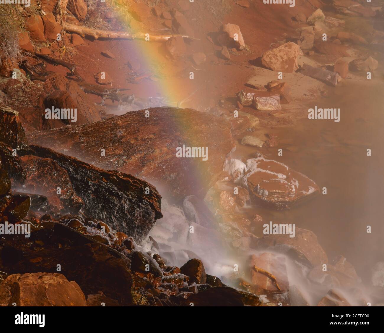 Zion National Park UT / MARZO UNA cascata arcobaleno archi su ghiaccio incrostati rocce alla base di un traboccamento proveniente da Emerald Pools. Foto Stock