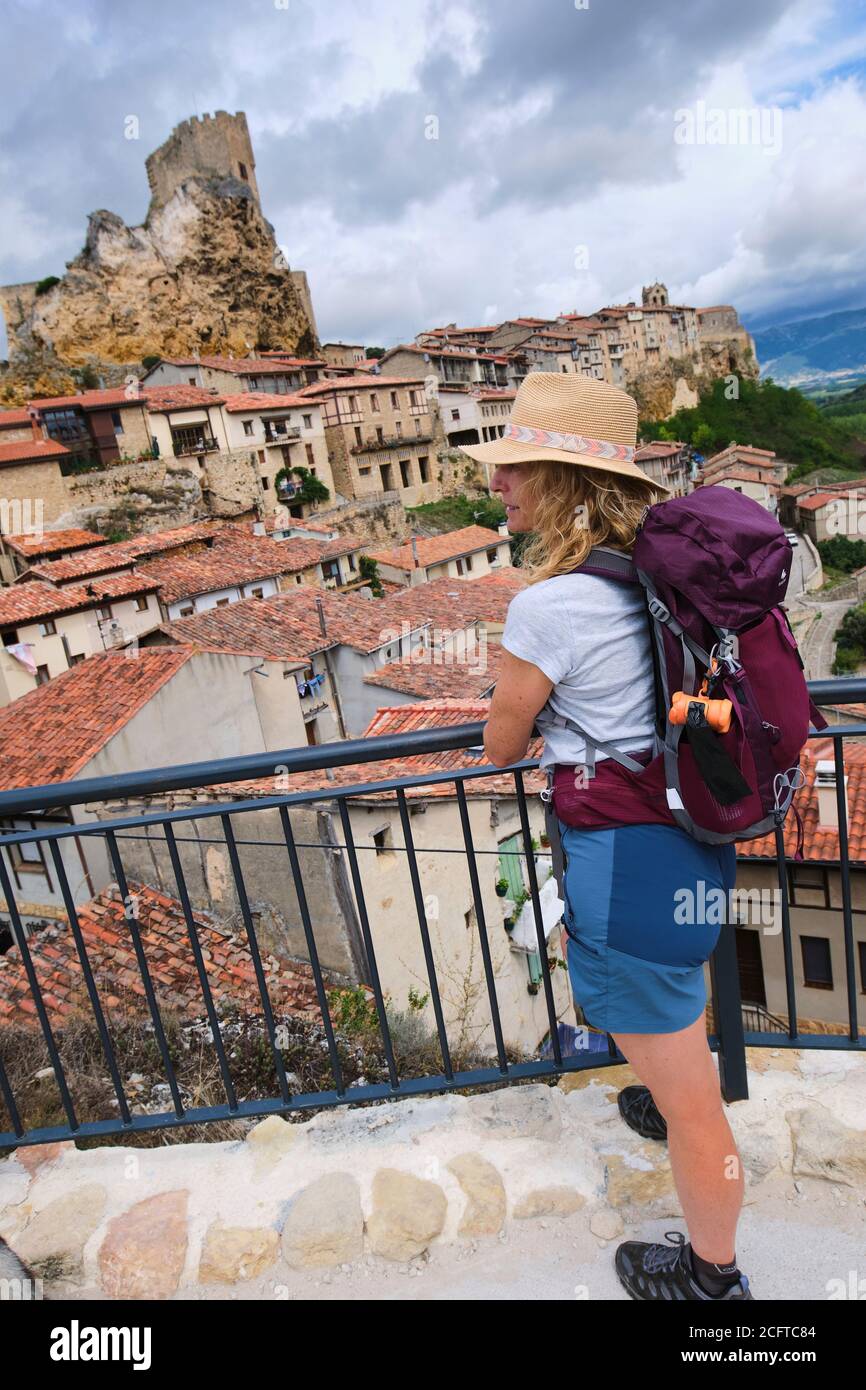 Giovane donna turistica matura con un cappello in un punto di vista di fronte a una città. Foto Stock