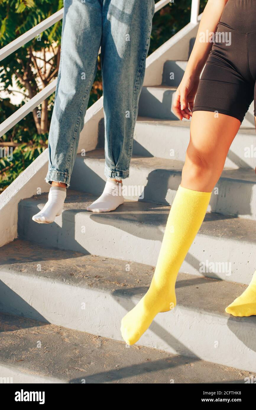 due ragazze scendono le scale in calze colorate senza scarpe. calzini  pubblicità concetto Foto stock - Alamy