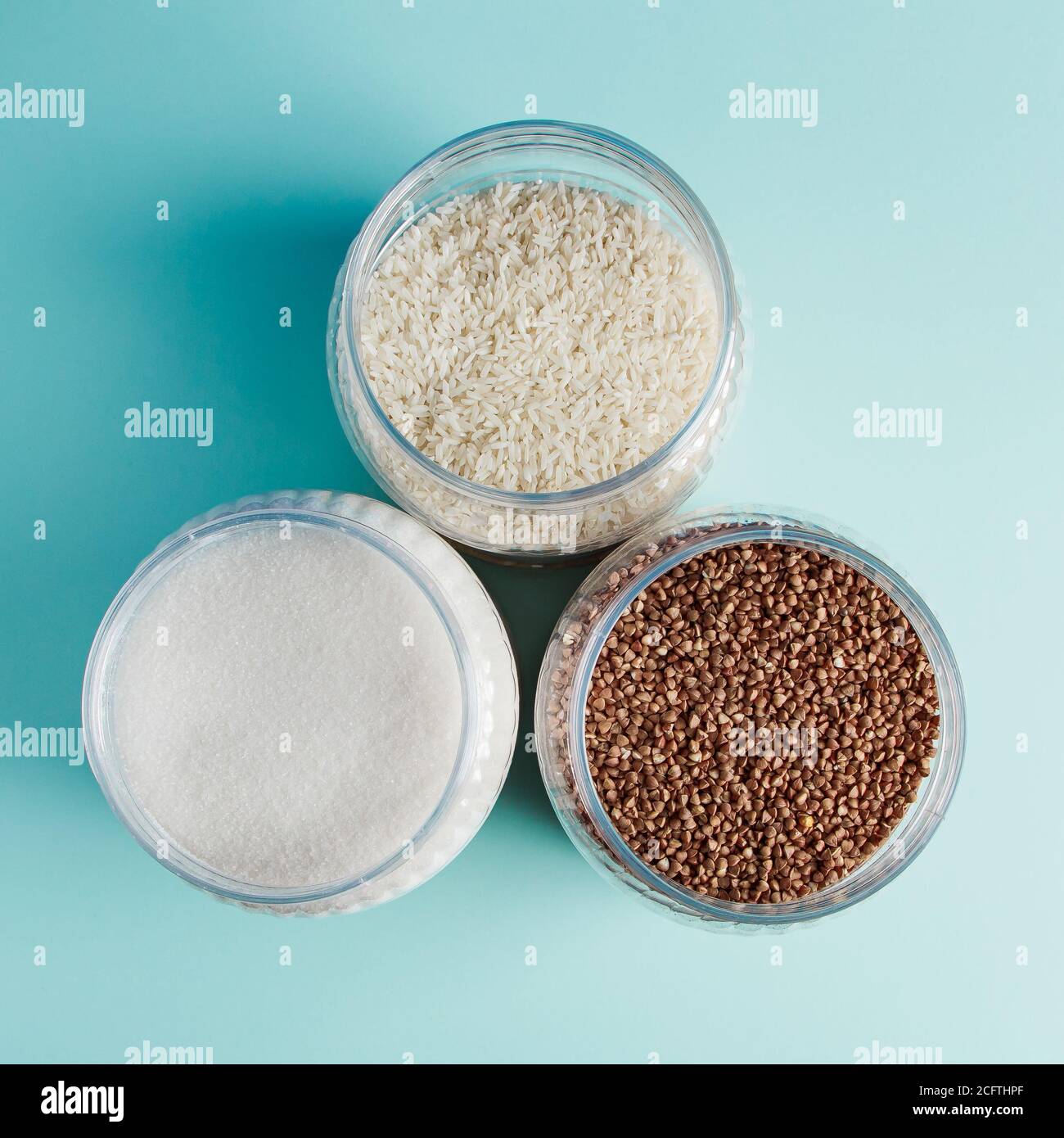 Primo piano vasi con cereali e zucchero su sfondo blu. Articoli essenziali per lo shopping in quarantena. Foto Stock