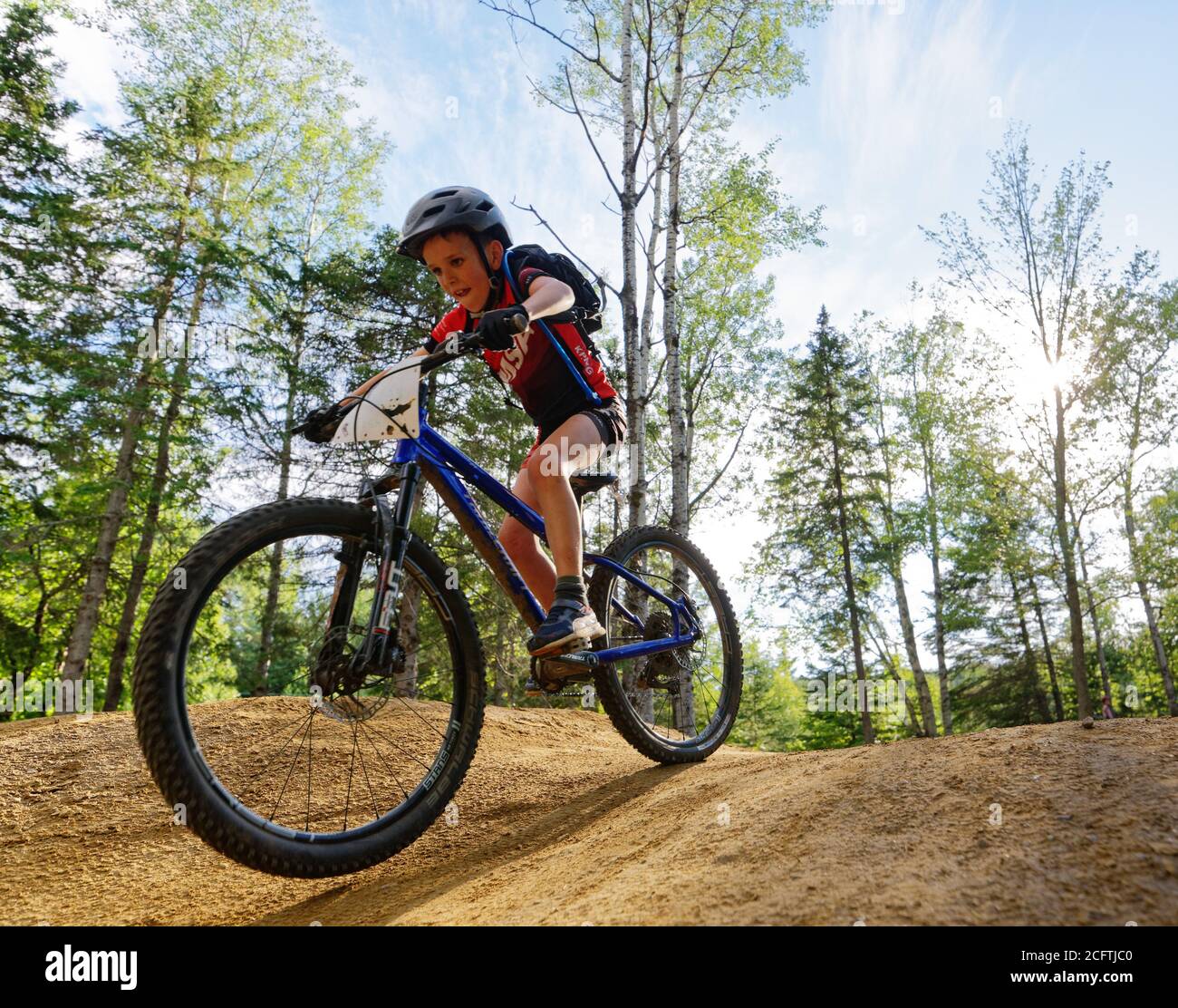 Un ragazzino (8 anni) saltando sulla sua mountain bike Foto Stock