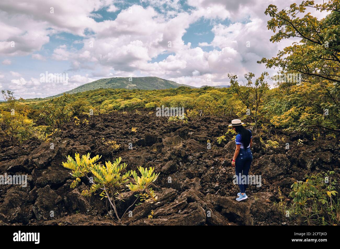 Una giovane donna che indossa un cappello che cammina sulla roccia vulcanica al parco nazionale del vulcano masaya Foto Stock