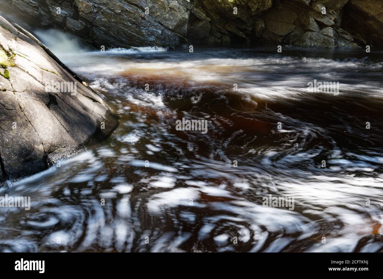 Schiuma vorticosa in un fiume Foto Stock