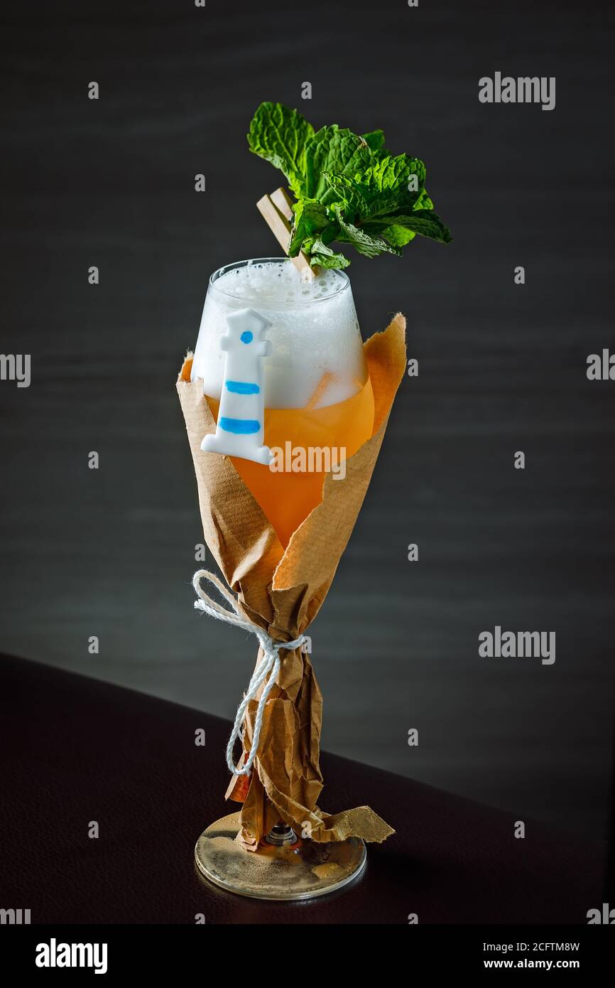 Un cocktail di classe servito in un bicchiere di champagne con un guarnire con menta e un faro di zucchero Foto Stock