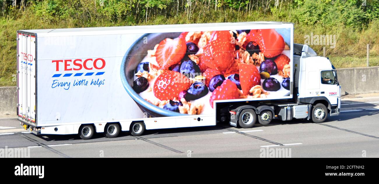 Vista laterale Tesco supermercato catena di approvvigionamento alimentare business store consegna marchio di autocarri e pubblicità grafica di frutta sulla guida di rimorchi Sull'autostrada del Regno Unito Foto Stock