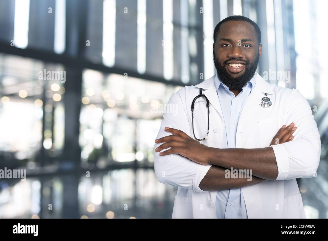 Sorridente medico è felice di vincere contro il coronavirus. Sfondo ciano Foto Stock