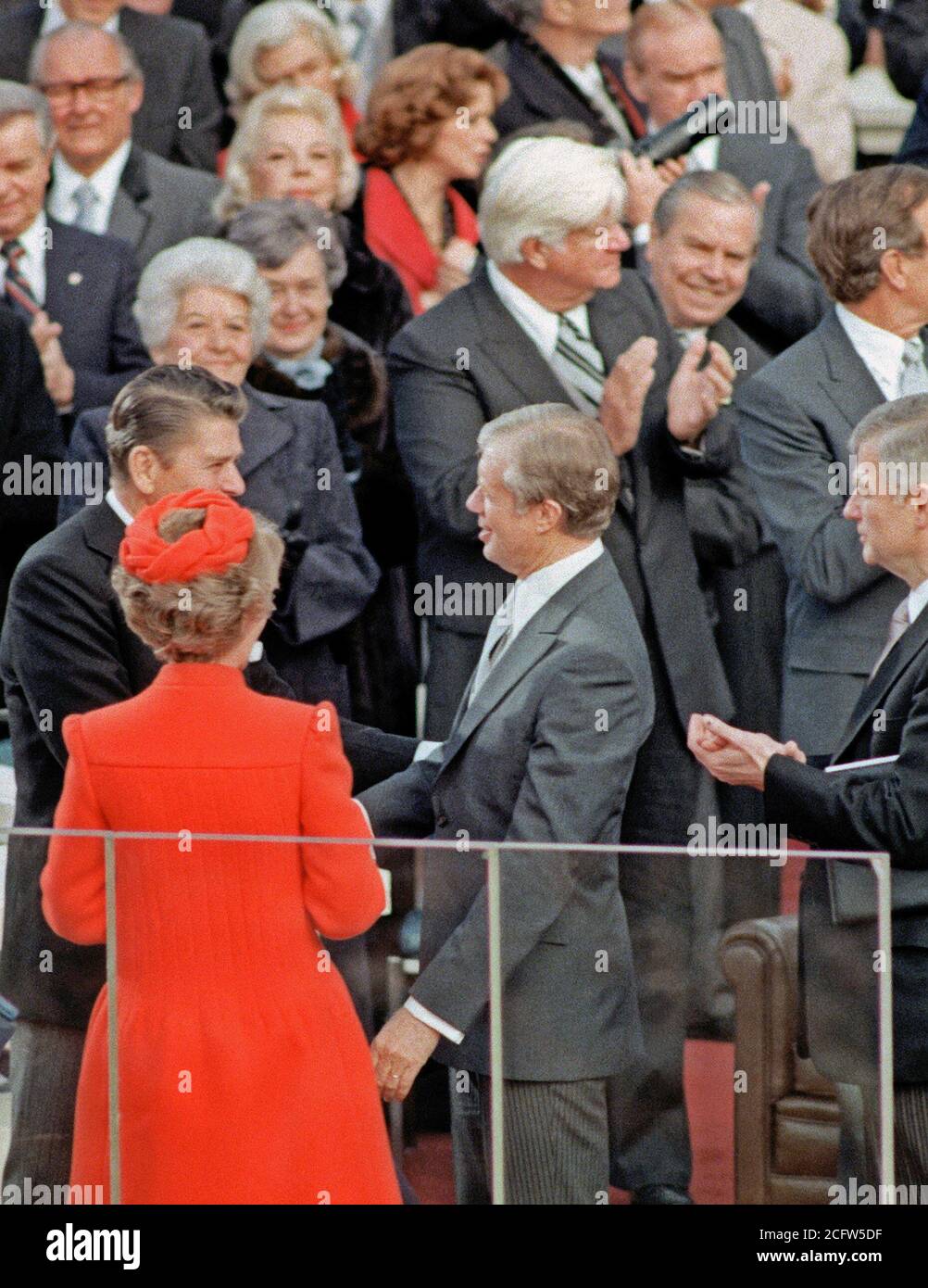 1981 - Presidente uscente Jimmy Carter si congratula con Ronald Reagan, il nuovo presidente, al Campidoglio durante il giorno dell'inaugurazione. Nancy Reagan si osserva la scena. Foto Stock