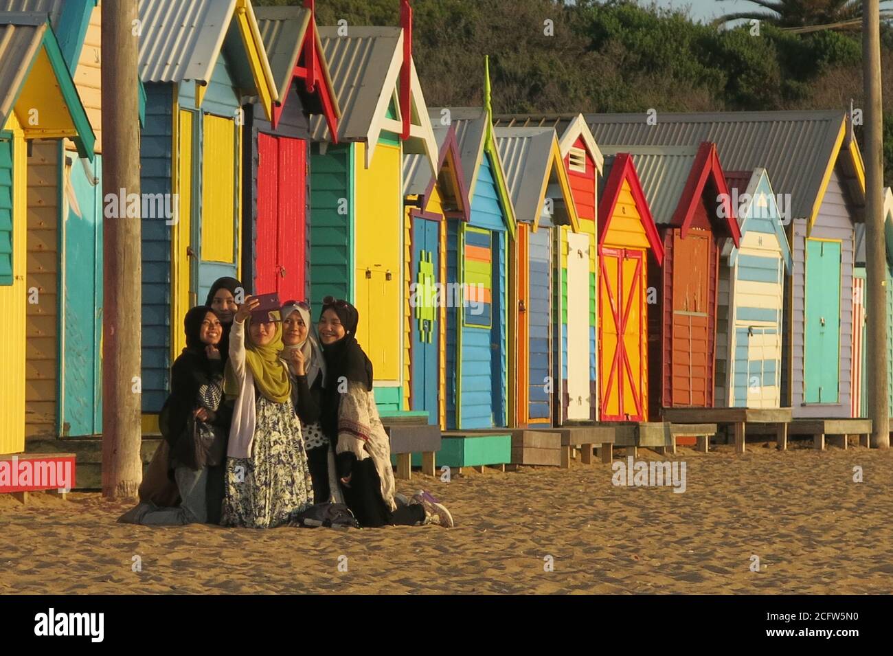 Melbourne Australia. Scene di vita quotidiana a Melbourne Australia . Un gruppo di amici scatta una foto selfie al Brighton Beach Boxes . Foto Stock