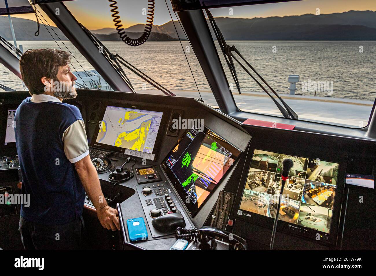 Il capitano Ben Bonnet controlla i monitor della telecamera di sicurezza sulla plancia della True North al largo della costa di Alor, Indonesia. Foto Stock