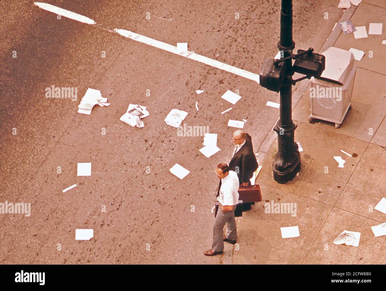 Riviste e quotidiani cucciolata l'intersezione dopo detriti è stato versato dal passaggio di un autocarro, settembre 1972 Louisville e questi due uomini sono ignari per le strade inquinate davanti a loro. Foto Stock