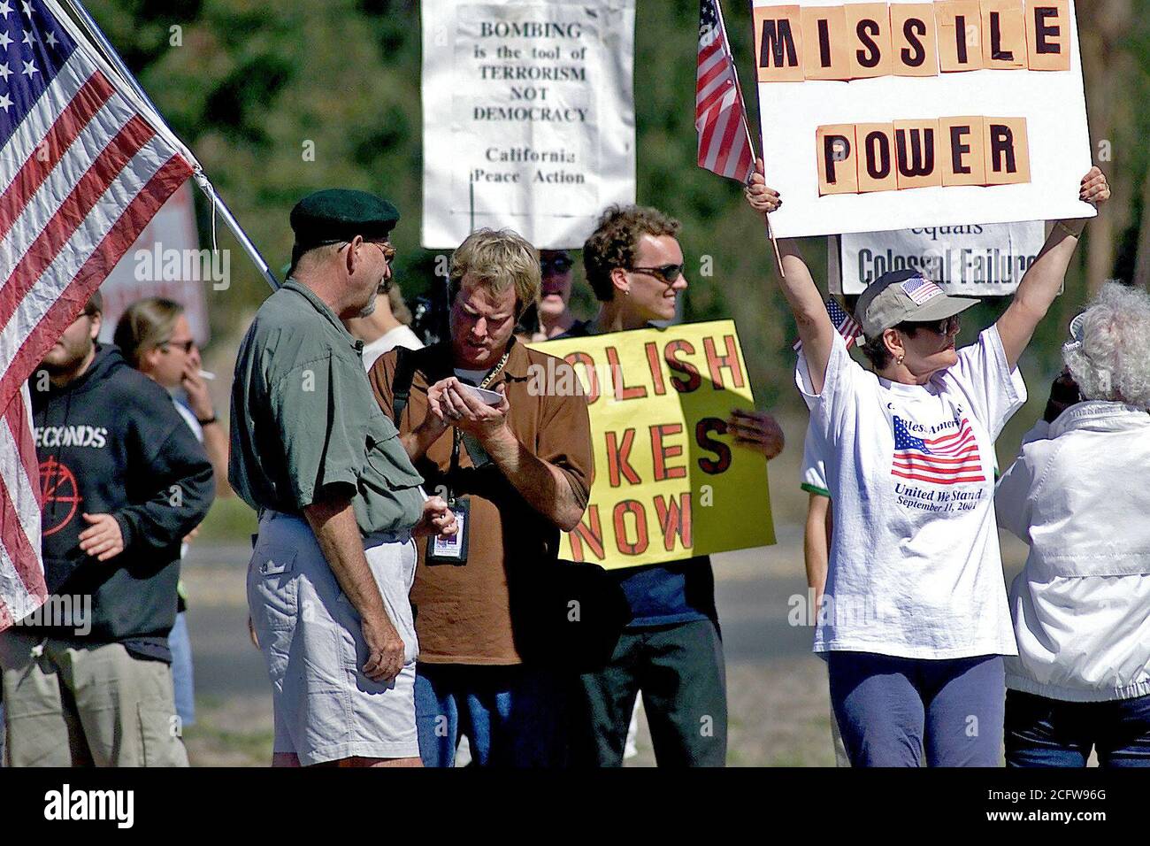2001 - manifestanti portando bandiere nordamericane e canta la linea Street vicino al cancello principale a Vandenberg AFB, CA a partecipare a un progetto di protesta, durante la giornata internazionale di protesta per fermare la militarizzazione dello spazio Foto Stock