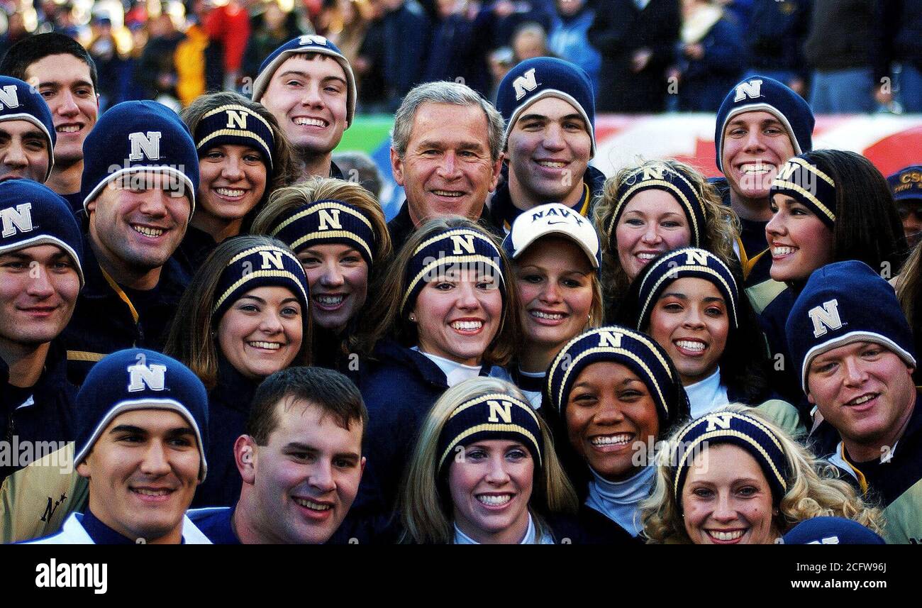 2004 - Il presidente statunitense George W. Bush huddles con le cheerleaders dalla US Naval Academy (USNA) in disparte durante le cerimonie di apertura per il 105° Army vs Navy gioco. La Marina Guardiamarina sconfitto esercito 42 a 13. Foto Stock