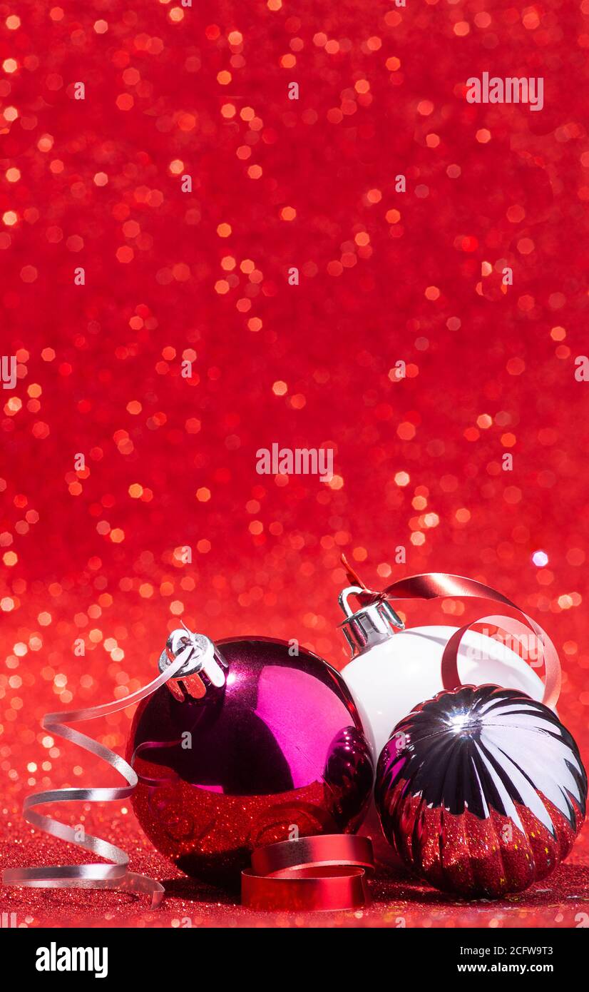 Palline di Natale su sfondo rosso glitter verticale Foto Stock