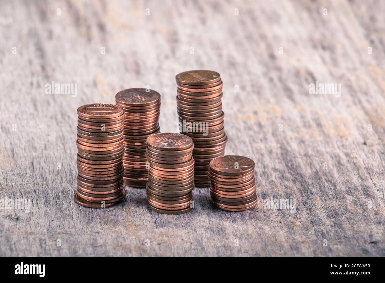 Pile di vecchi penny su un tavolo di legno Foto Stock