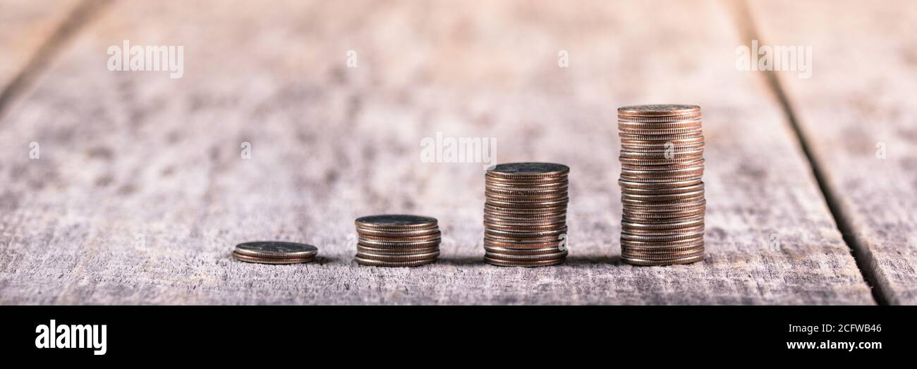 Pile di quarti su un vecchio tavolo di legno / investimento concetto di crescita Foto Stock