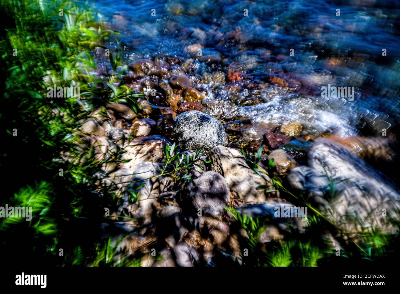spruzzi artistici di acqua centrati su una roccia al Bordo del lago Tahoe Foto Stock
