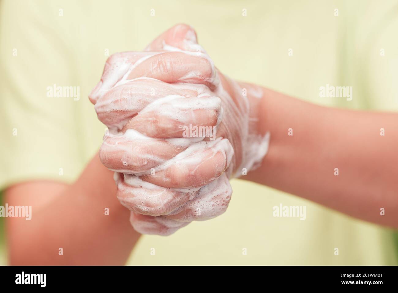 Vista frontale sulle mani del bambino con schiuma di sapone, concetto di igiene personale Foto Stock