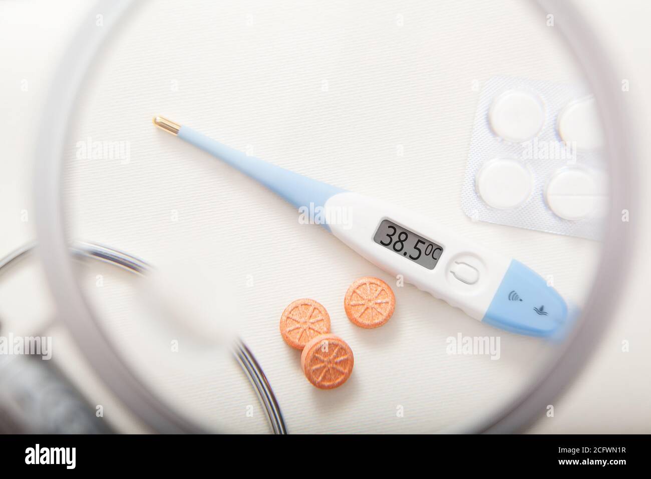 Termometro elettronico con temperatura di 38.5 gradi e pillole Foto Stock