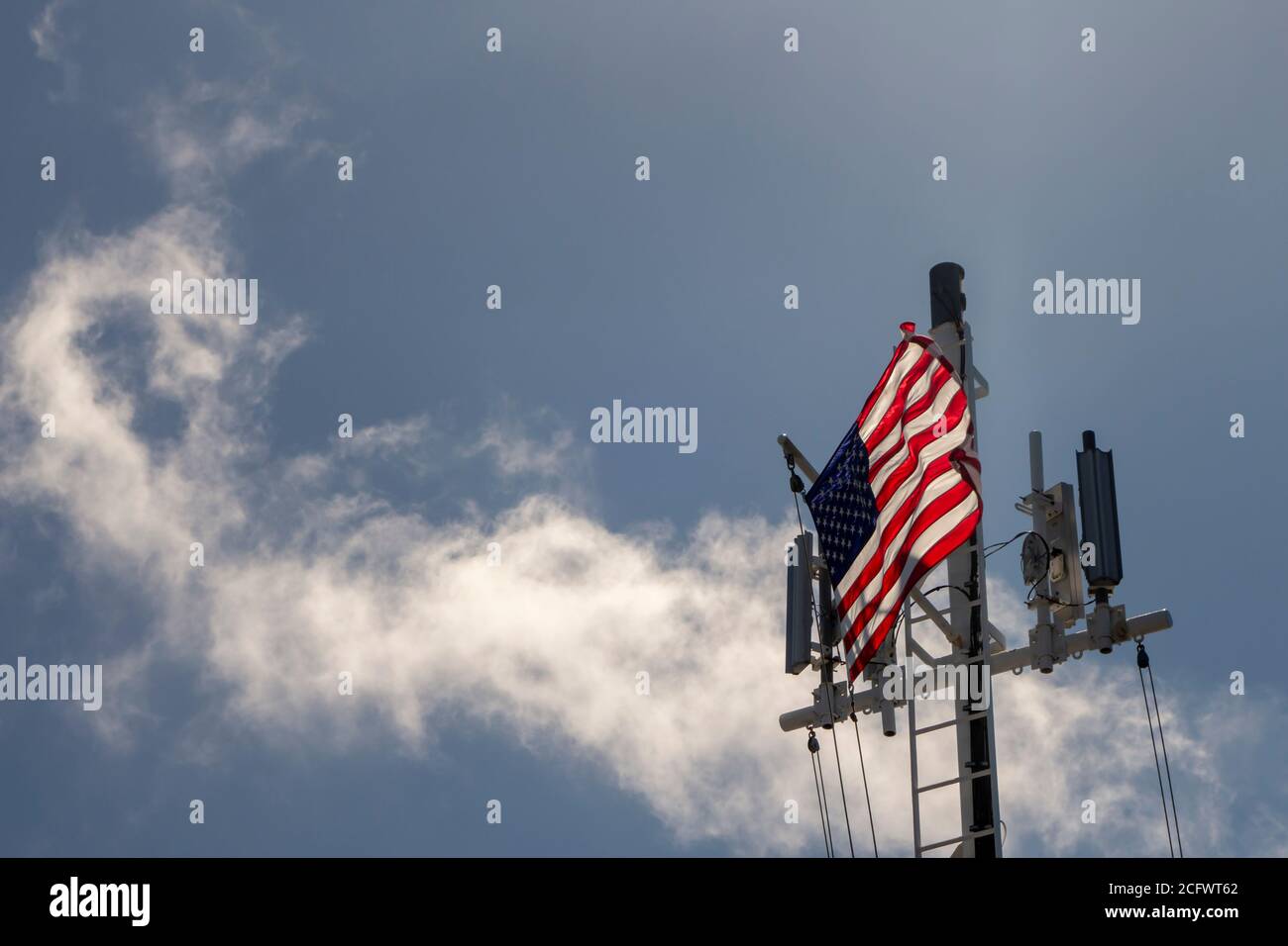 Il ponte di una grande nave a nel mare Con torri cellulari Stati Uniti d'America Flag soffiando in Il vento Foto Stock