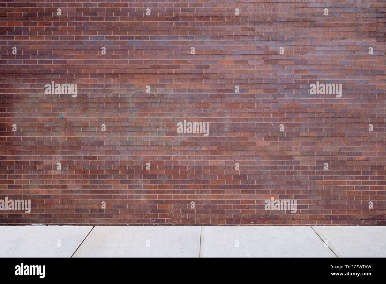 marciapiede esterno con parete in mattoni rossi Foto Stock
