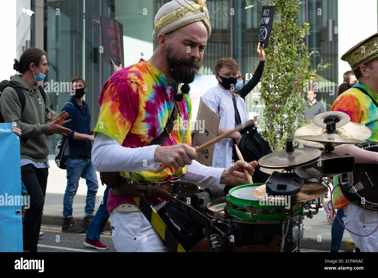 Extinction Rebellion protesta, Manchester, Regno Unito. La tranquilla sfilata di ribellione guidata dai secondi liner di Wilson. Batterista che cammina nella sfilata. Foto Stock