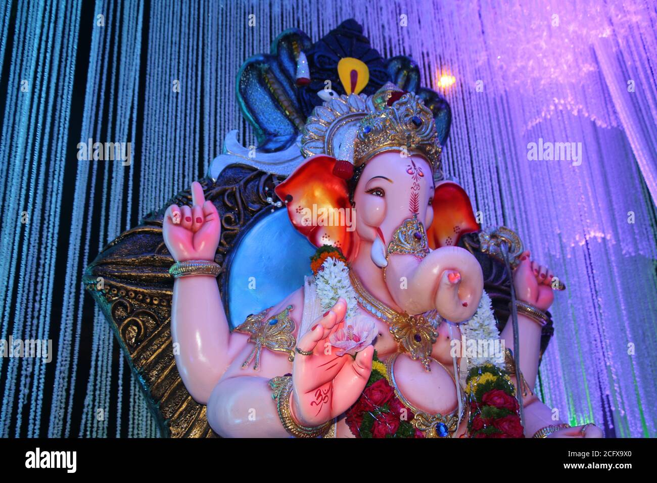 Idolo Ganesh con splendido sfondo bianco. Primo piano dalla mano verso il viso. Foto Stock