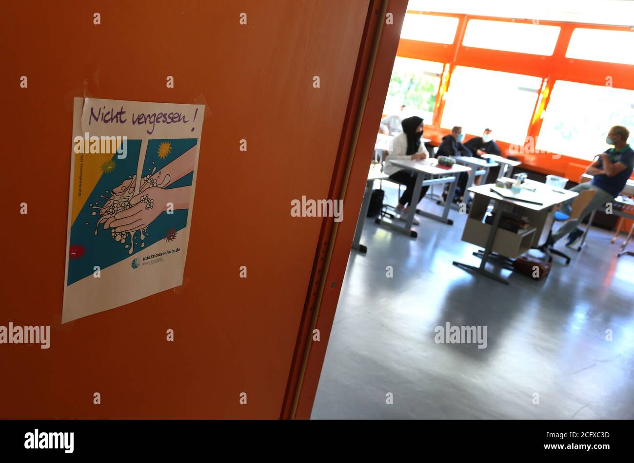 Bayern, Germania. 8 settembre 2020. Gli allievi di un nono grado di una scuola media si siedono con i boccagli accanto ad un segno che ricorda loro di mantenere la loro distanza il primo giorno della scuola. Credit: Karl-Josef Hildenbrand/dpa/Alamy Live News Foto Stock
