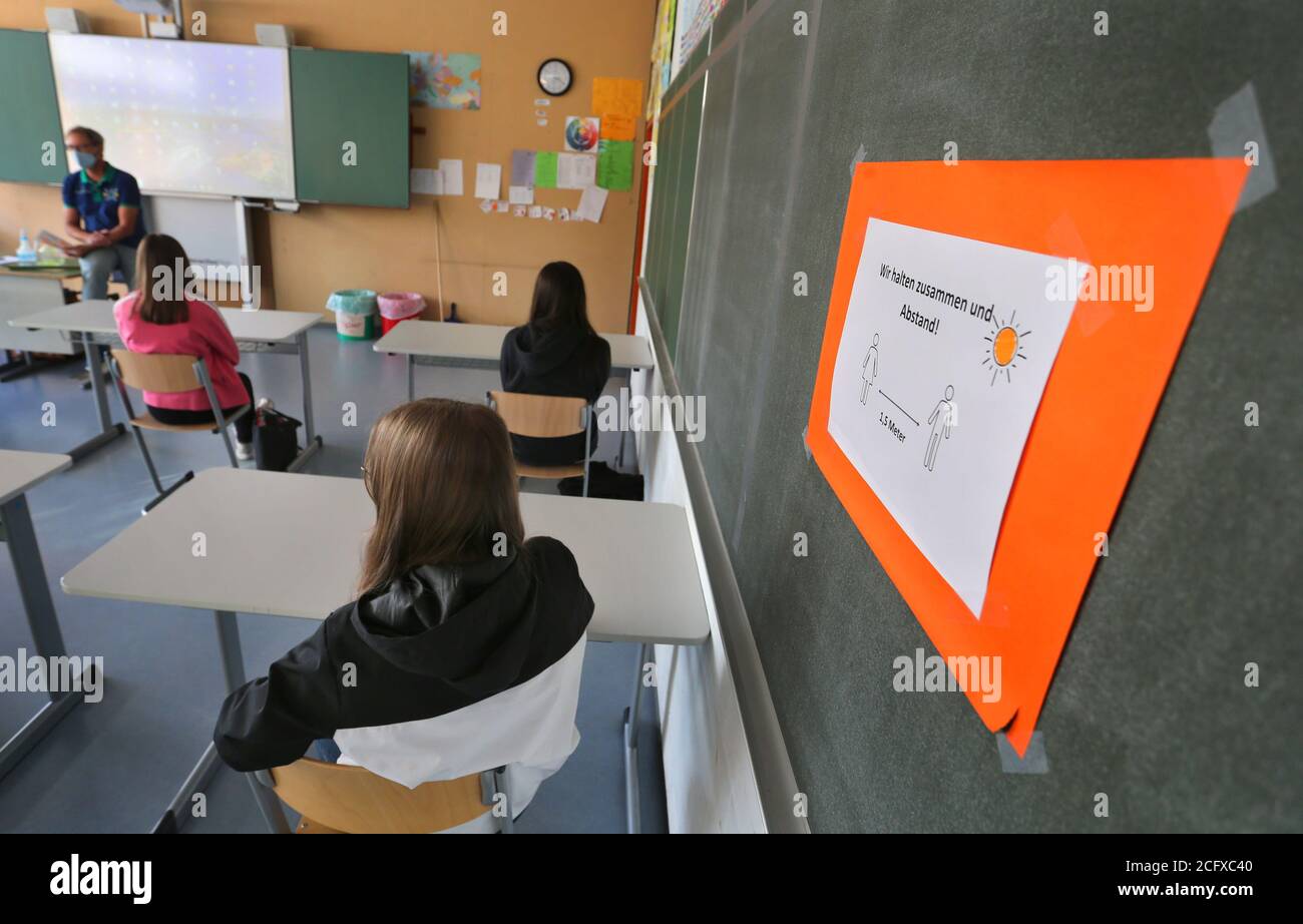 Bayern, Germania. 8 settembre 2020. Gli allievi di un nono grado di una scuola media si siedono con i boccagli accanto ad un segno che ricorda loro di mantenere la loro distanza il primo giorno della scuola. Credit: Karl-Josef Hildenbrand/dpa/Alamy Live News Foto Stock