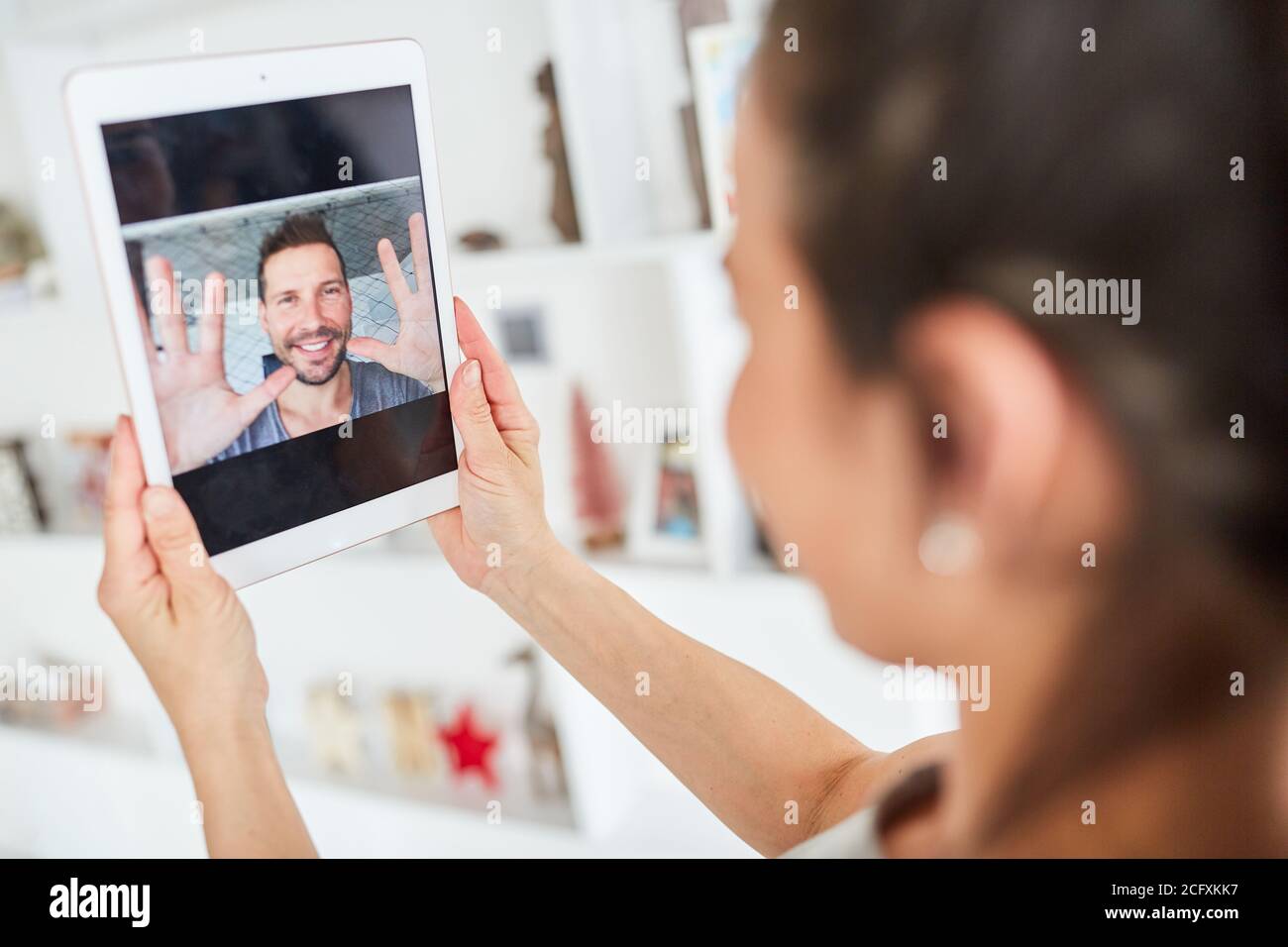 La giovane donna che usa il computer tablet è una chat video con lei partner online Foto Stock