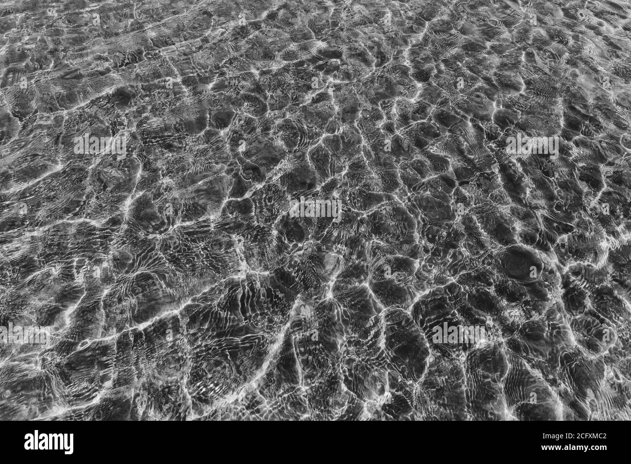 Vista dall'alto, la superficie delle acque cristalline si riflette sulla spiaggia di sabbia poco profonda. Foto Stock