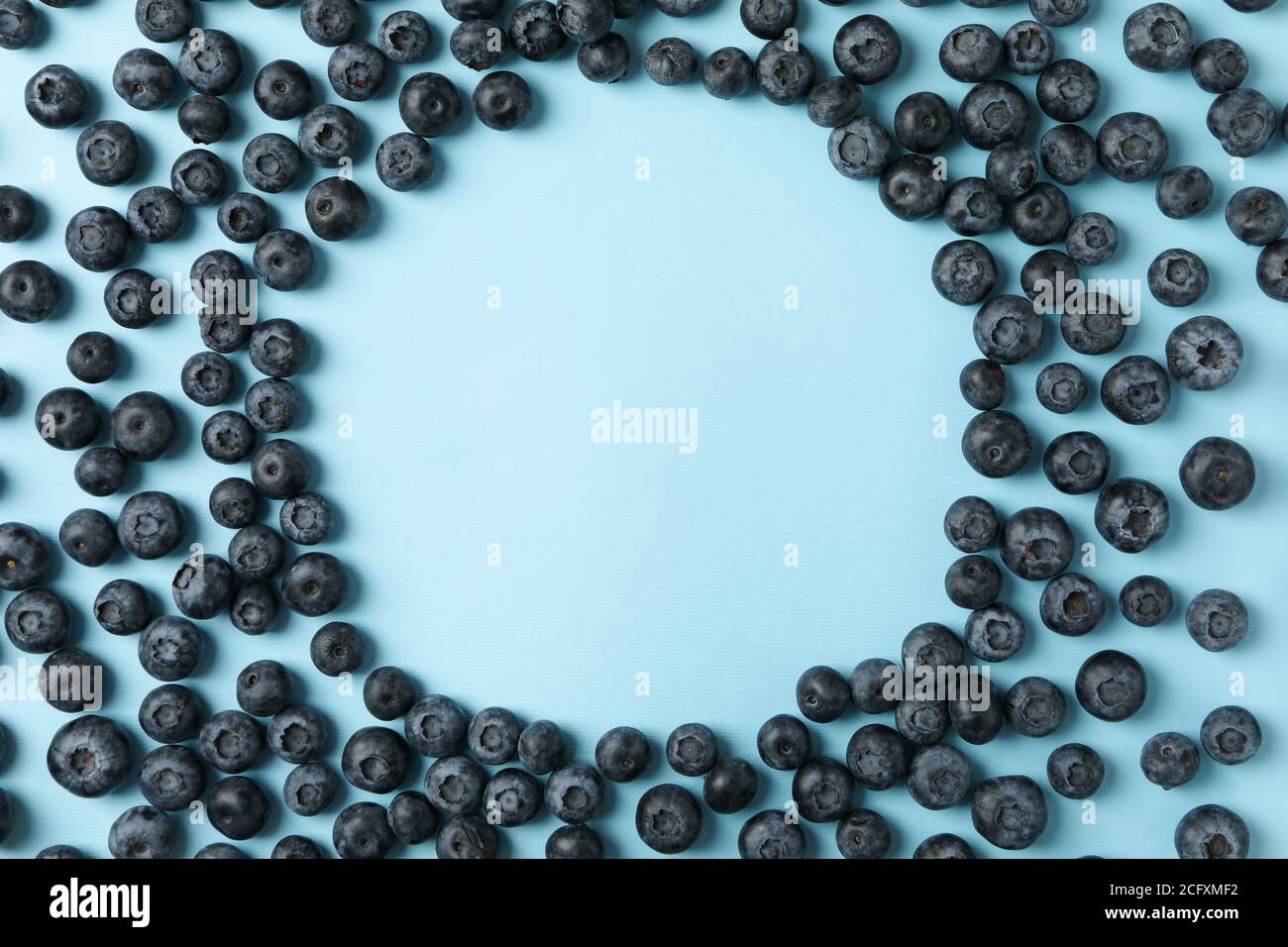 Cerchio di mirtilli su sfondo blu, spazio per il testo Foto Stock