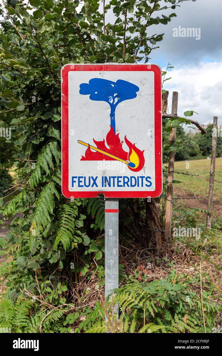Cartello "fuoco vietato" scritto in francese in un paesaggio di campagna. Nessun segno di incendio con corrispondenza illuminata . Incendi non consentiti. Foto Stock