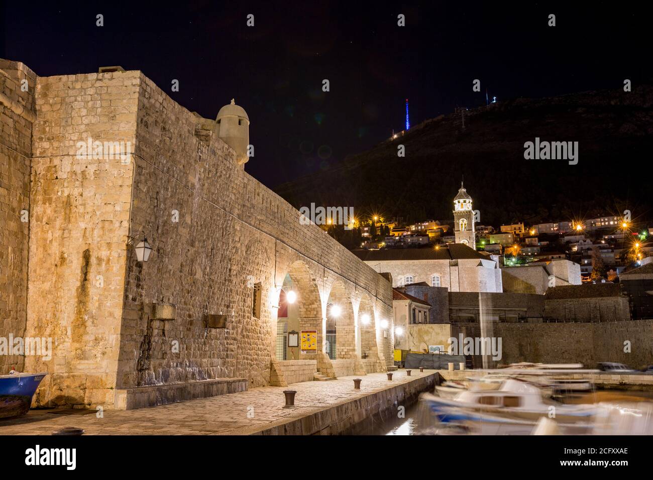 Porto con motoscafi sfocati e diffrazione della luce, lunga esposizione di notte. Scenario vista invernale della città vecchia mediterranea di Dubrovnik, viaggi europei e destinazione storica, Croazia Foto Stock