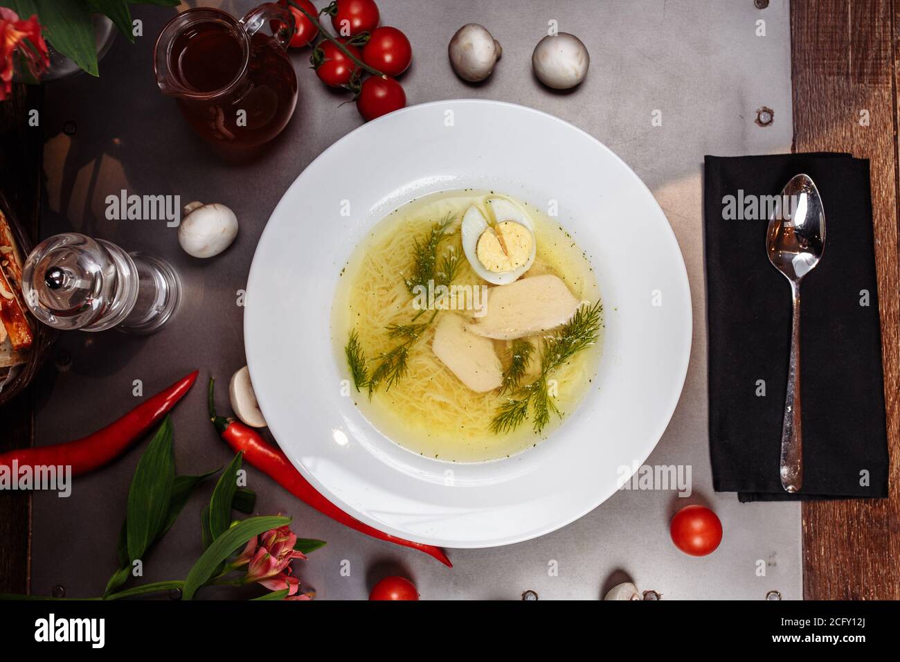 Una ciotola bianca piena di deliziosa zuppa di noodle di pollo Foto Stock