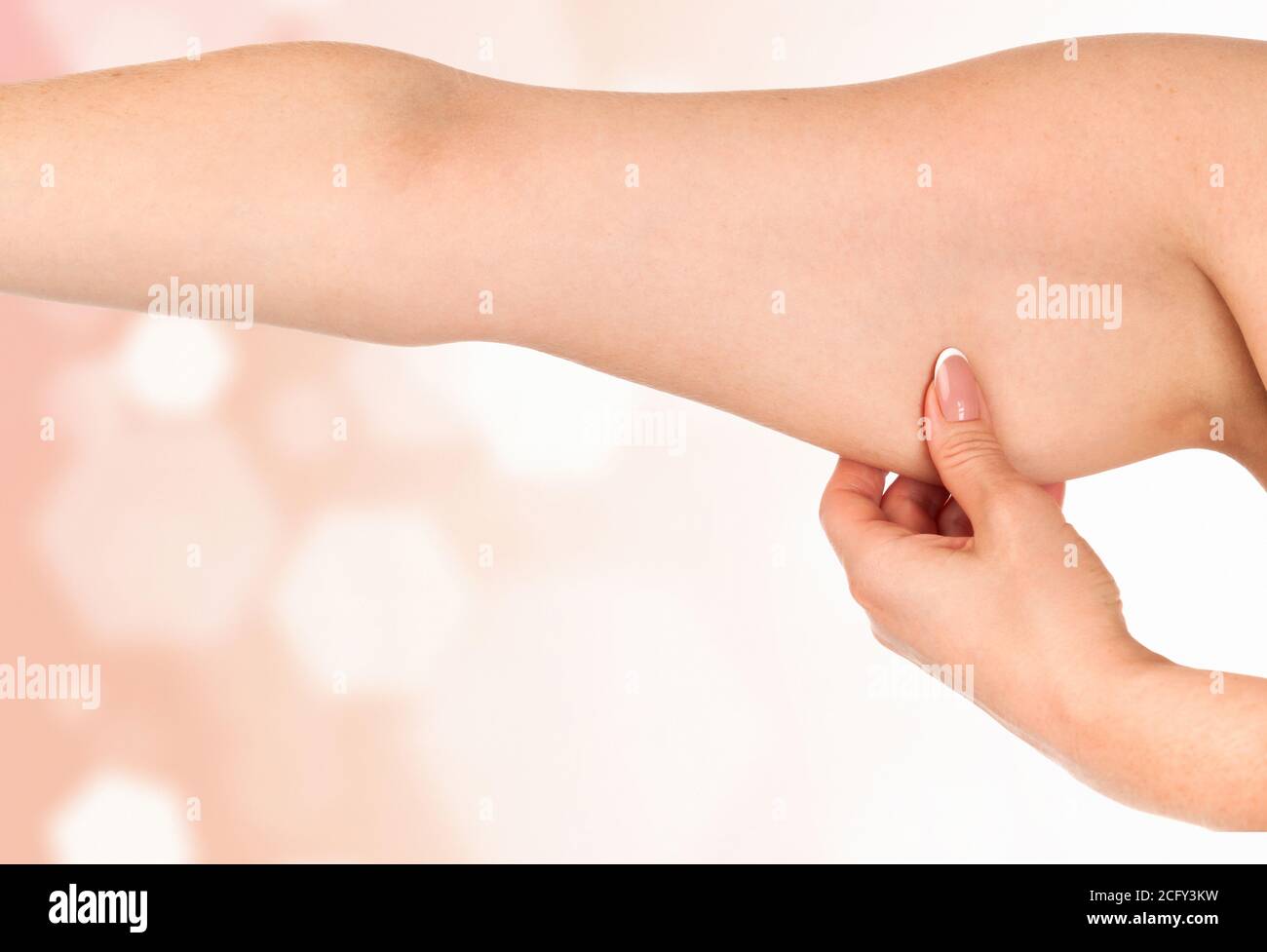 Donna che tiene la mano con grasso in eccesso contro un astratto sfondo con luci svasate e copyspace Foto Stock