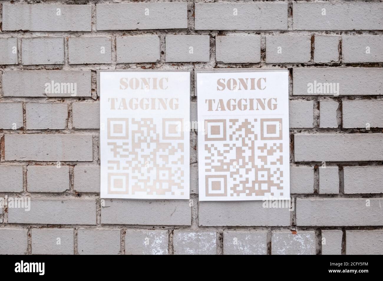 Poster per artista Sonic Tagging montato su parete in mattoni con Codice QR Foto Stock