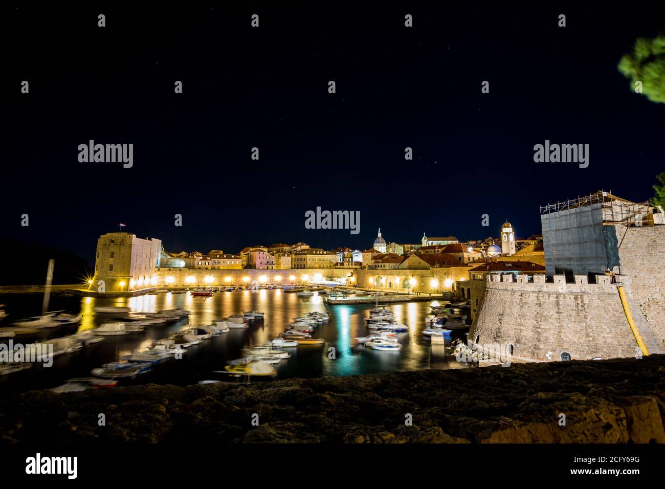 Porto con motoscafi sfocati e diffrazione della luce, lunga esposizione di notte. Scenario vista invernale della città vecchia mediterranea di Dubrovnik, viaggi europei e destinazione storica, Croazia Foto Stock