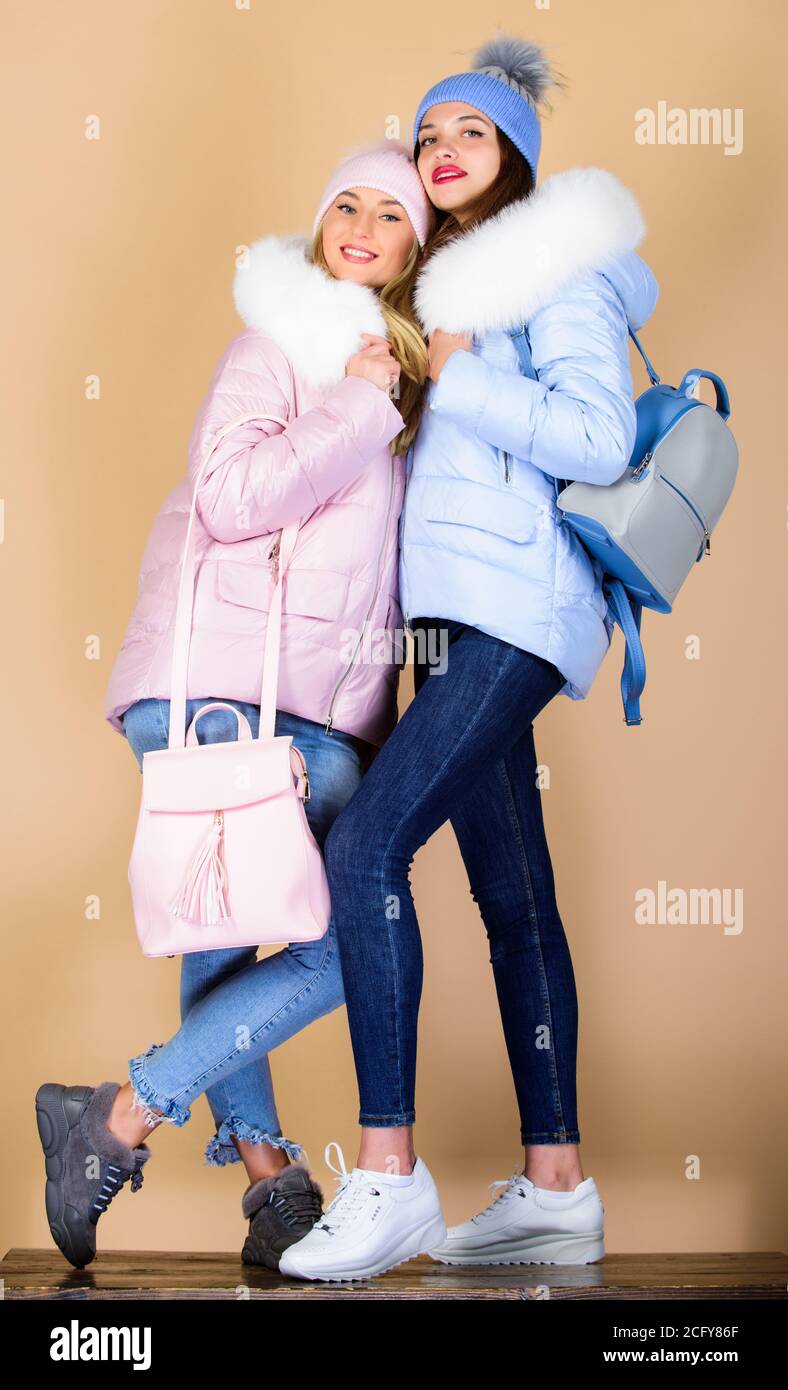 vita studentesca. abbigliamento invernale. giacca in giù. influenza e freddo. shopping stagionale. ragazze in bambina con borsa in pelle. buone vacanze invernali. Amici studenti. Donne in cappotto caldo imbottito. natale. Foto Stock