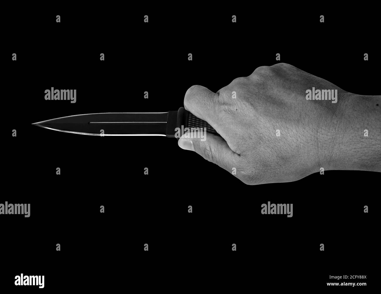 Closeup mano tenendo un coltello da combattimento isolato su sfondo nero, bianco e nero con percorso di ritaglio Foto Stock