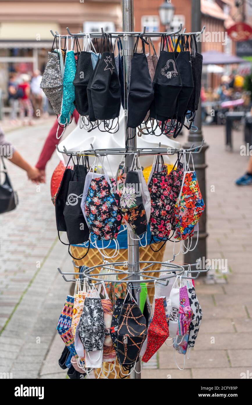 Stand con diverse maschere a bocca, maschere protettive, in tessuto, di fronte a una boutique a Lüneburg, bassa Sassonia, Germania Foto Stock