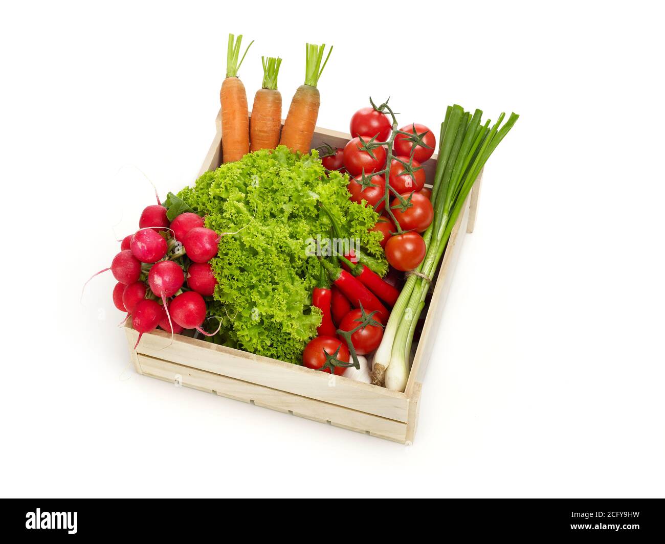 Verdure in una cassa di legno isolata su bianco Foto Stock