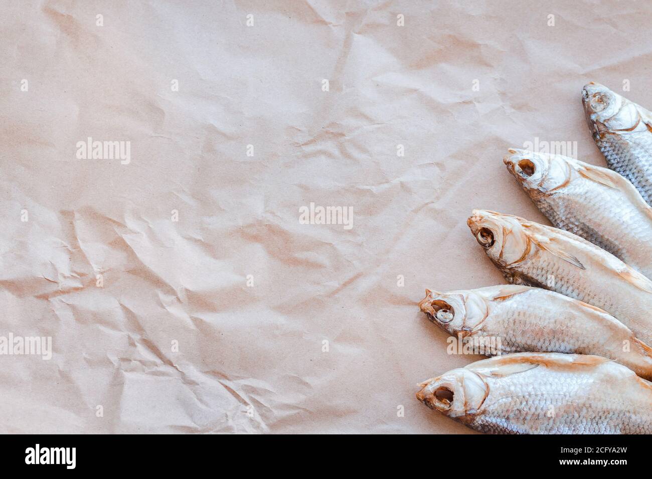 Banner modello pesci secchi su sfondo di carta artigianale con spazio vuoto per il testo. Rivestimento piatto in rete di roach salato. Poster per spuntini di pesce, dépliant decorativo. Cornice di pesce per il negozio di promozione. Foto Stock
