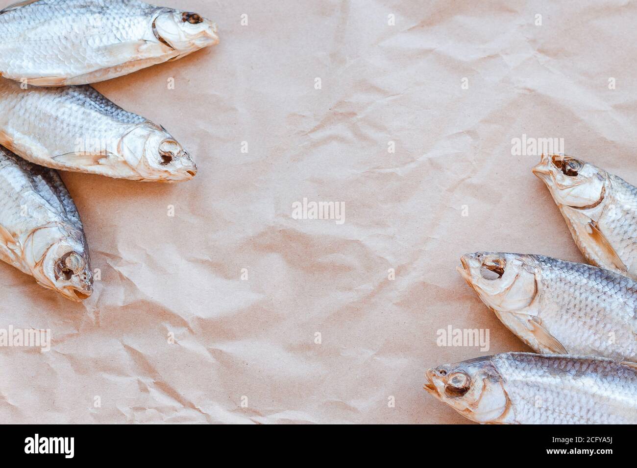 Banner modello pesci secchi su sfondo di carta artigianale con spazio vuoto per il testo. Rivestimento piatto in rete di roach salato. Poster per spuntini di pesce, dépliant decorativo. Cornice di pesce per il negozio di promozione. Foto Stock