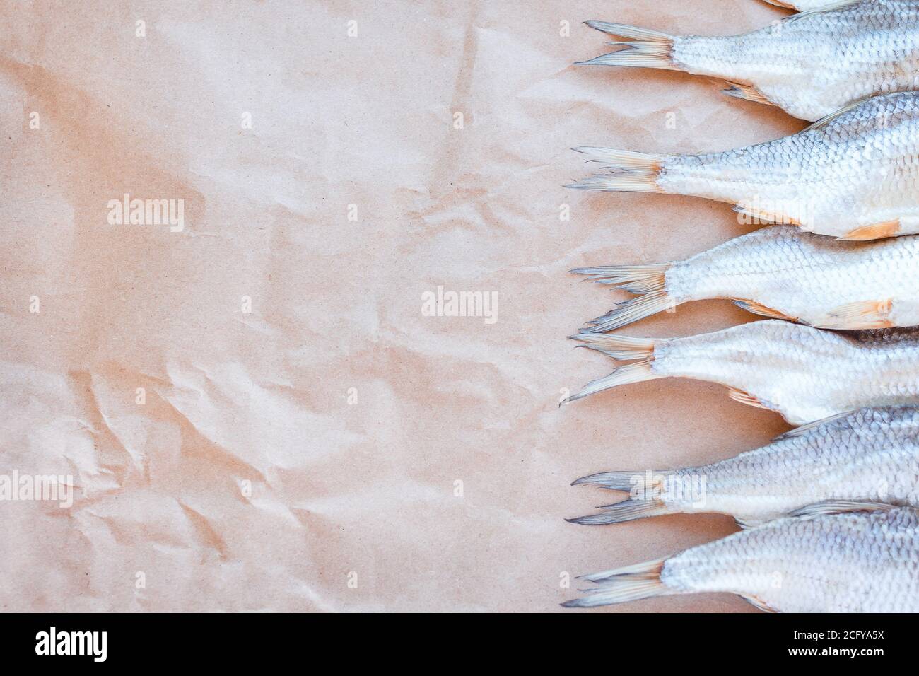 Banner modello pesci secchi su sfondo di carta artigianale con spazio vuoto per il testo. Rivestimento piatto in rete di roach salato. Poster per spuntini di pesce, dépliant decorativo. Cornice di pesce per il negozio di promozione. Foto Stock