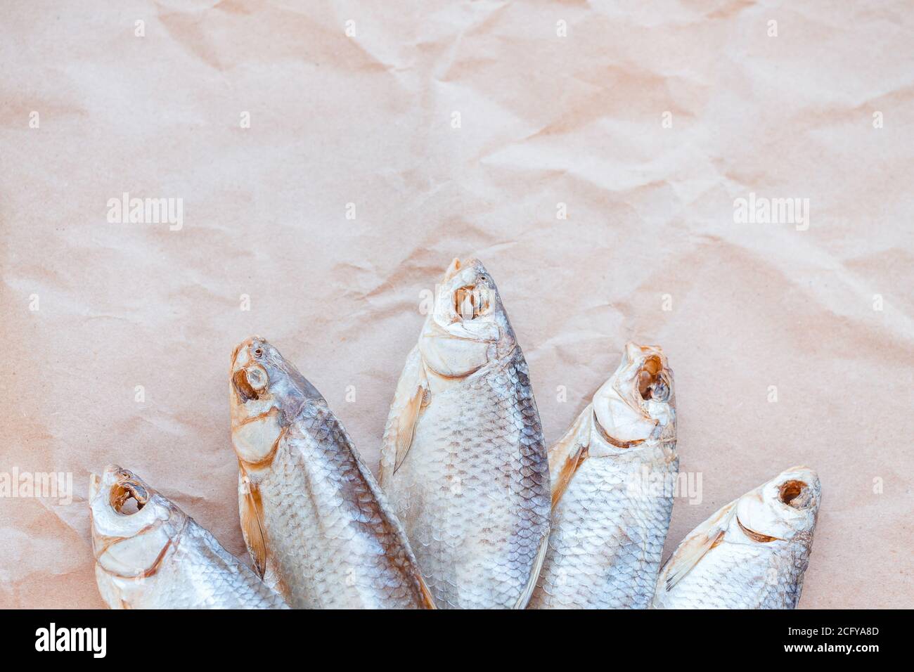 Banner modello pesci secchi su sfondo di carta artigianale con spazio vuoto per il testo. Rivestimento piatto in rete di roach salato. Poster per spuntini di pesce, dépliant decorativo. Cornice di pesce per il negozio di promozione. Foto Stock